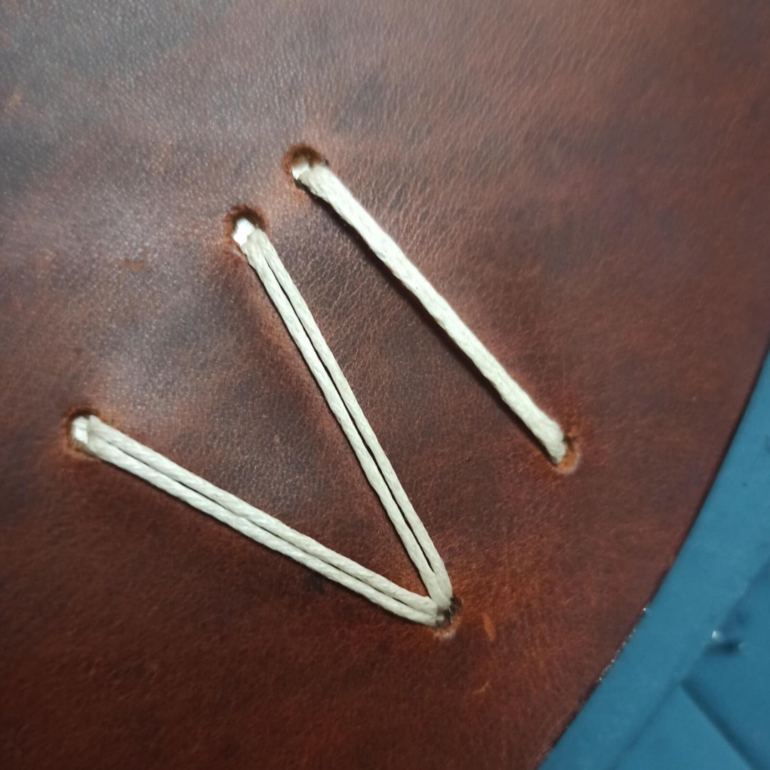 Ένα κομψό ρολόι τοίχου από καφέ δέρμα και με λευκό μηχανισμο.